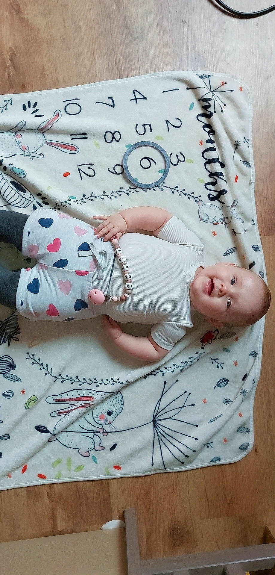 Ambre a rejoint le concours — aidez-le/la à gagner de superbes lots ! arm, baby, baby_toddler_clothing, child, comfort, creative_arts, elbow, flesh, font, happy, linens, pattern, person, pink, product, sleeve, textile, thigh, toddler, white