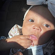 Kataleya joined the competition — help win amazing prizes! baby, closeup, face, child, headband, bow, hand, fingers, sunlight, shadow, clothing, tag, floral_pattern, cute, infant, portrait, skin, eyes, nose, mouth