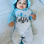 Corey is registered to the contest to win money with this photo: baby, infant, child, portrait, lying_down, bed, bedding, white_background, blue_outfit, hood, bunny_ears, easter, onesie, holiday, clothing, face, eyes, looking_at_camera, indoor, cute
