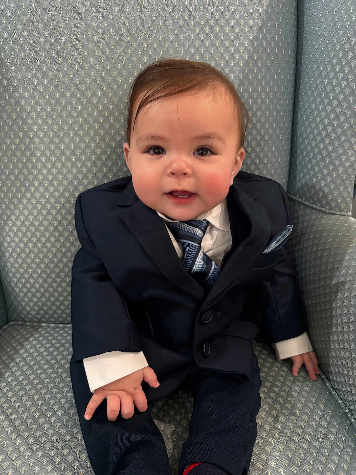 Ares joined the competition — help win amazing prizes! baby, child, suit, tie, armchair, smile, cute, formal_clothing, person, indoor, portrait, young_child, fashion, seated, hands, face, hair, buttoned_jacket, patterned_fabric, candid