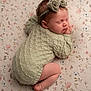 Ottilie is registered to the contest to win money with this photo: baby, newborn, sleeping, knitted_outfit, headband, bow, floral_pattern, blanket, cute, peaceful, infant, soft_texture, portrait, resting, child, small, toddler, cozy, skin, closed_eyes