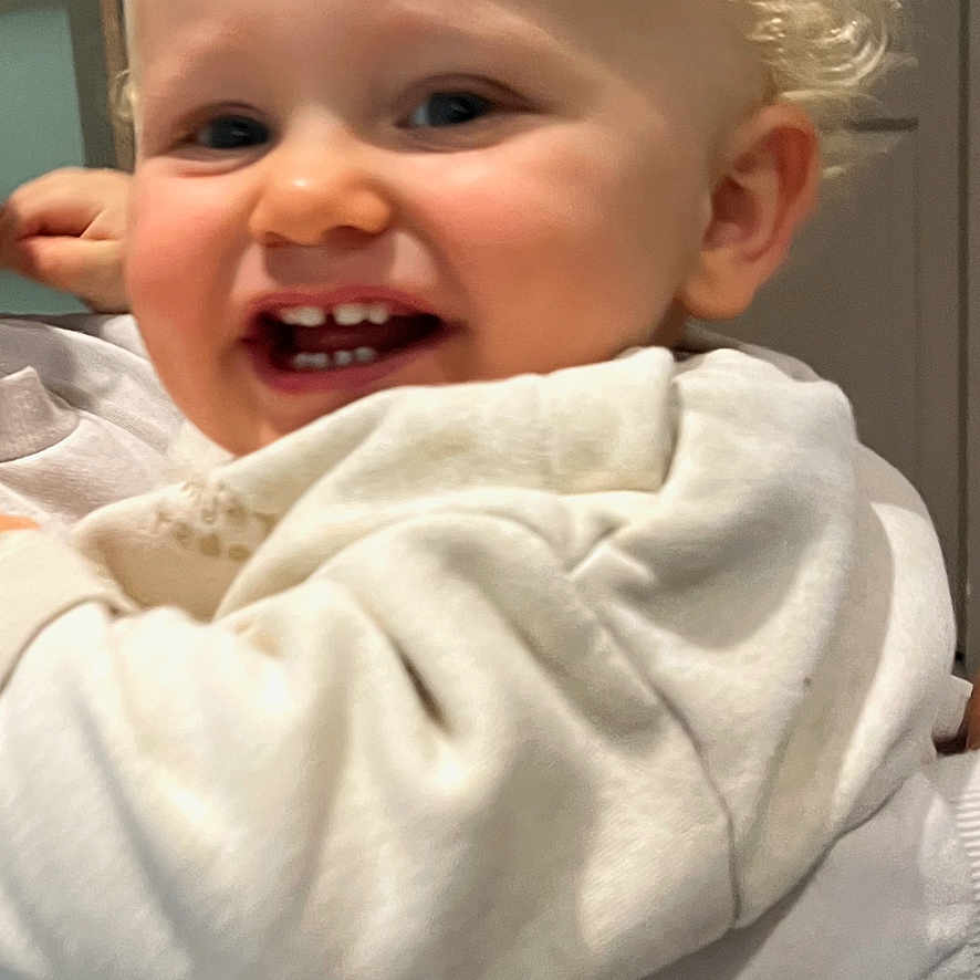 Farel participe au concours pour gagner de l'argent avec cette photo : baby, blonde_hair, cheerful, child, closeup, clothing, curly_hair, cute, face, family, happy, holding, human, indoor, person, portrait, smile, sweater, toddler, warm