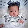 baby, child, face, glasses, sunglasses, white_clothing, embroidery, furniture, blanket, fur, portrait, cute, infant, person, indoors, fashion, headwear, hands, expression, soft
