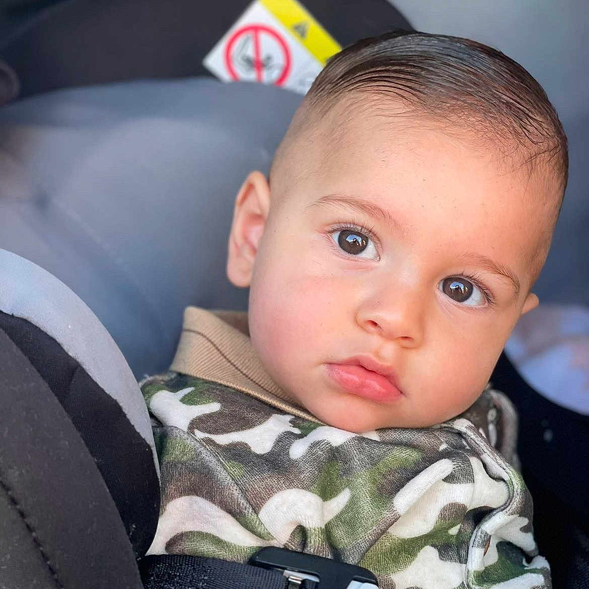 Malonne participe au concours pour gagner de l'argent avec cette photo : baby, camouflage, car_seat, child, closeup, clothing, expression, eyes, face, hair, hoodie, indoors, person, portrait, safety, seat, seatbelt, skin, toddler, young_child