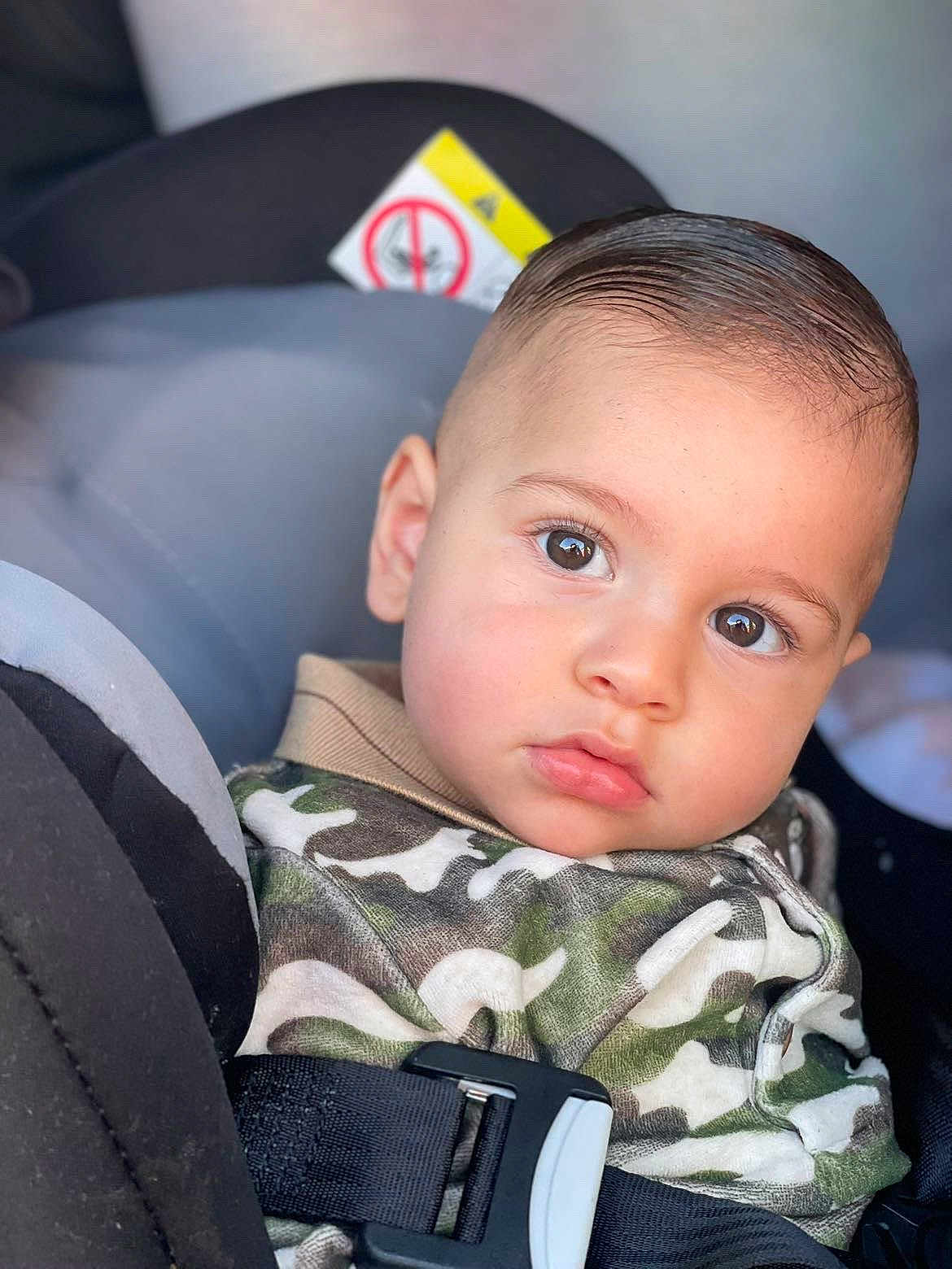 Malonne participe au concours pour gagner de l'argent avec cette photo : baby, camouflage, car_seat, child, closeup, clothing, expression, eyes, face, hair, hoodie, indoors, person, portrait, safety, seat, seatbelt, skin, toddler, young_child