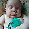 baby, sleeping, pacifier, polka_dot, cushion, rainbow, animal_print, infant, child, skin, hand, face, closeup, peaceful, rest, indoors, cute, soft_light, comfortable, portrait