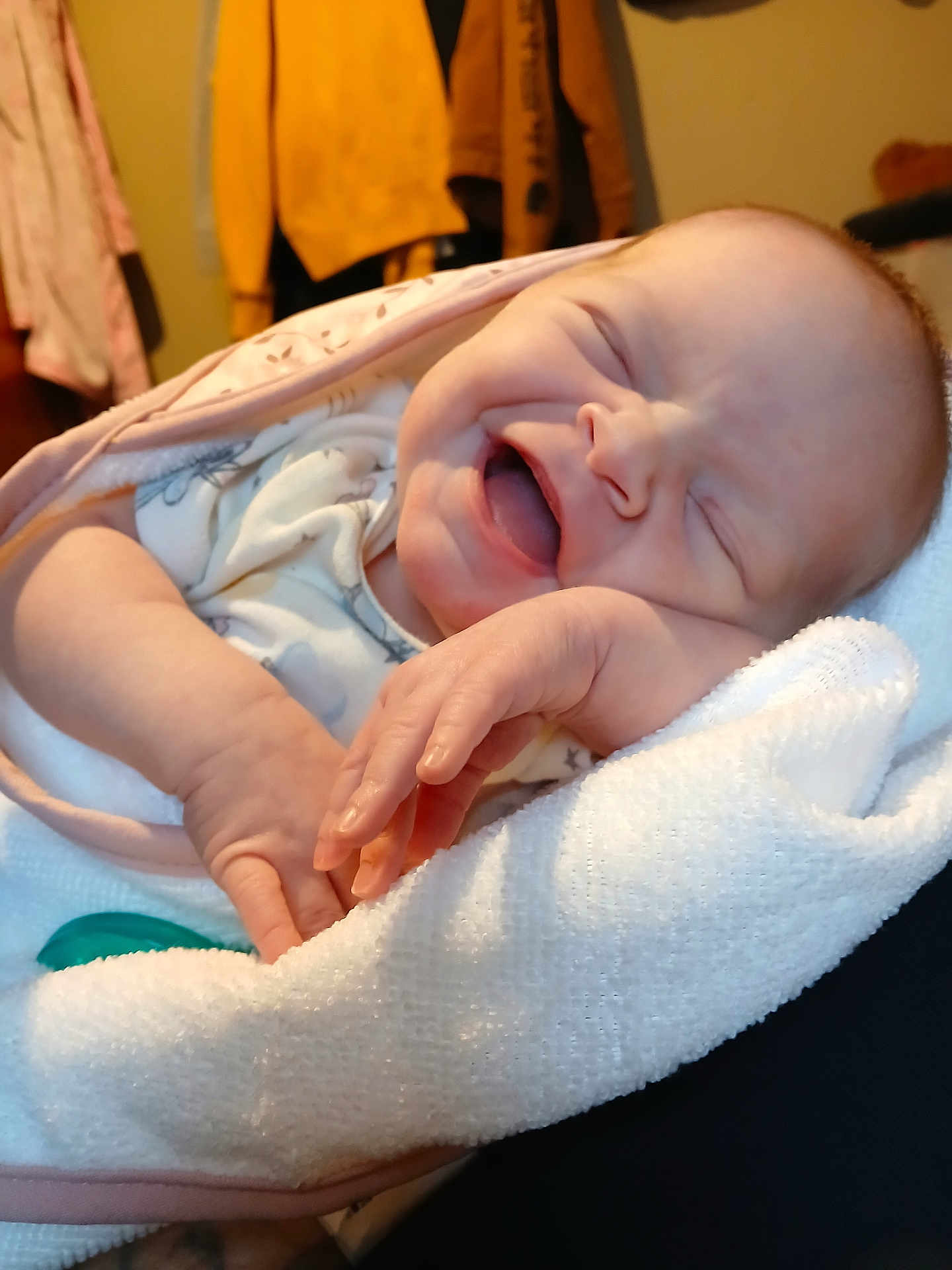 Riley is registered to the contest to win money with this photo: baby, infant, newborn, sleeping, yawning, smiling, blanket, swaddle, towel, hand, fingers, face, portrait, closeup, cozy, indoor, clothing, pacifier, jacket, bedding