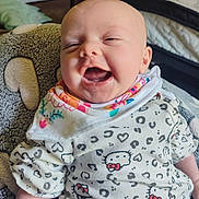 Isabelle is registered to the contest to win money with this photo: baby, bib, child, clothing, cozy, cute, expression, face, happy, head, hello_kitty, home, indoor, infant, joy, pattern, plush_chair, portrait, sitting, smiling