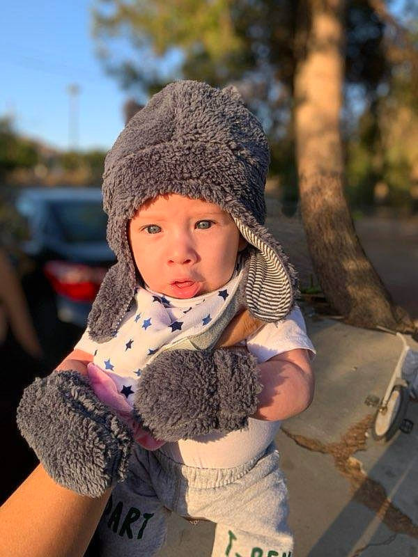 Niko joined the competition — help win amazing prizes! baby, beanie, bonnet, cap, child, child_model, fur, hat, headgear, knit_cap, person, toddler, tree, wool
