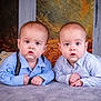 baby, twin_babies, infant, portrait, studio, lying_down, blue_shirts, suspenders, pants, siblings, curious_expression, wide_eyes, hands, blanket, floor, backdrop, autumn_background, wood_pillars, photography, cute