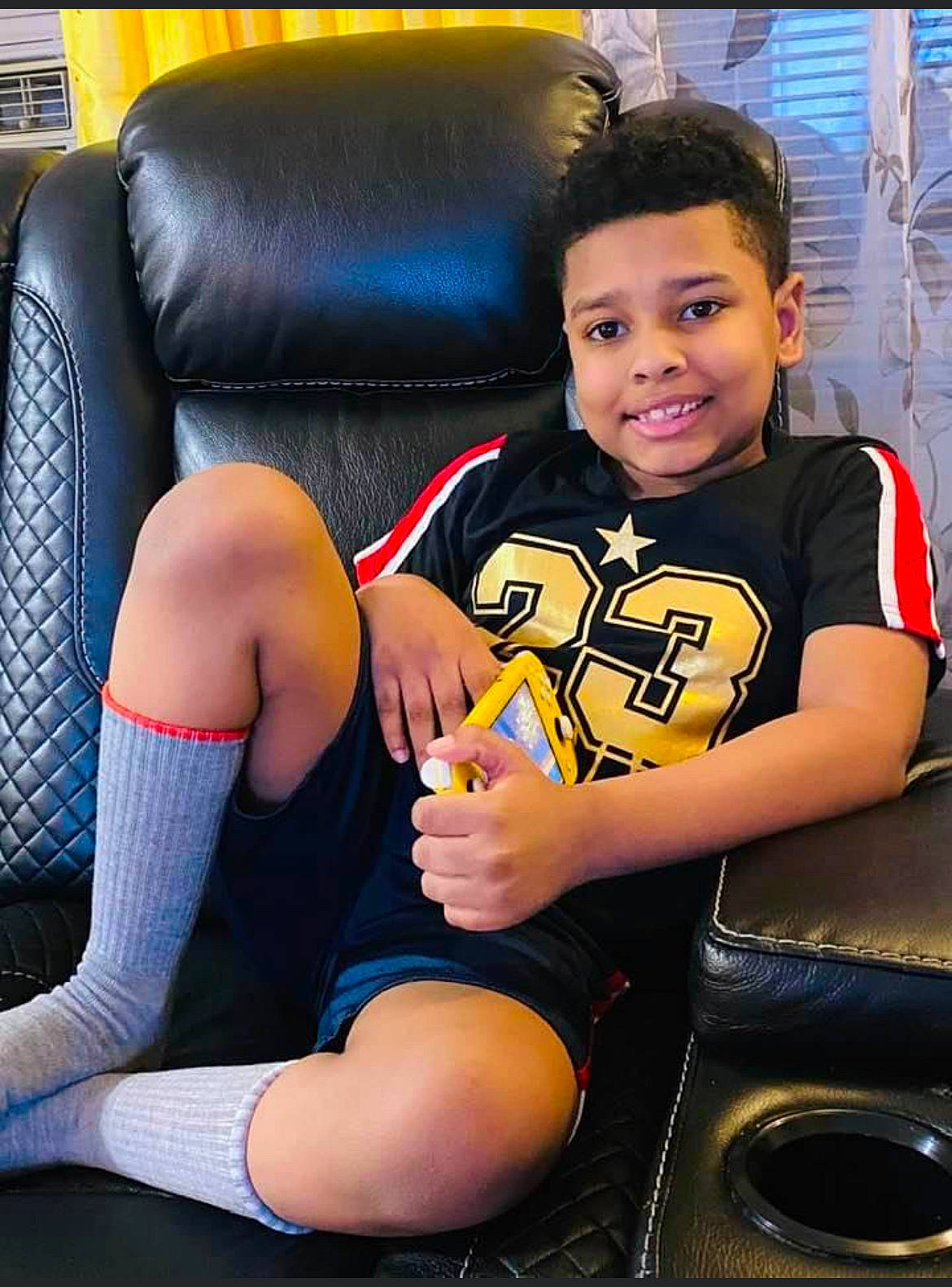 Jose is registered to the contest to win money with this photo: black_hair, chair, comfort, electric_blue, flash_photography, fun, hair, hairstyle, happy, human_body, human_leg, joint, joy, knee, lap, leg, leisure, person, shorts, sitting