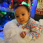 Serinity is registered to the contest to win money with this photo: baby, infant, child, onesie, blanket, fluffy, christmas_tree, holiday_lights, decorations, festive, face, curious, indoors, cozy, portrait, soft_lighting, cute, holiday, warm, colorful