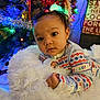 baby, infant, child, onesie, blanket, fluffy, christmas_tree, holiday_lights, decorations, festive, face, curious, indoors, cozy, portrait, soft_lighting, cute, holiday, warm, colorful