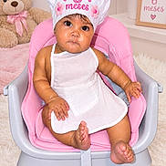 Addie joined the competition — help win amazing prizes! baby, infant, child, high_chair, birthday, six_months, chef_hat, pink, white_dress, teddy_bear, portrait, sitting, face, smiling, indoor, nursery, flowers, framed_sign, pastel, celebration