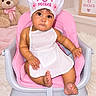 baby, infant, child, high_chair, birthday, six_months, chef_hat, pink, white_dress, teddy_bear, portrait, sitting, face, smiling, indoor, nursery, flowers, framed_sign, pastel, celebration