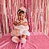 Addie joined the competition — help win amazing prizes! baby, child, infant, smiling, happy, portrait, pink, dress, headband, flower, sitting, blanket, sequins, sparkly, party, indoor, photography, fashion, cute, celebration