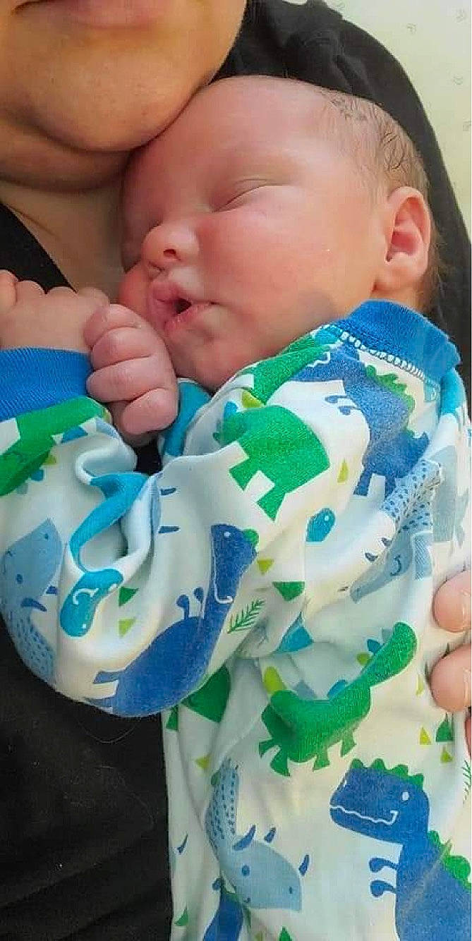 Alexander is registered to the contest to win money with this photo: baby, baby_toddler_clothing, blue, cheek, child, comfort, drinkware, facial_expression, finger, gesture, green, hand, happy, mouth, nail, neck, nose, person, skin, thumb