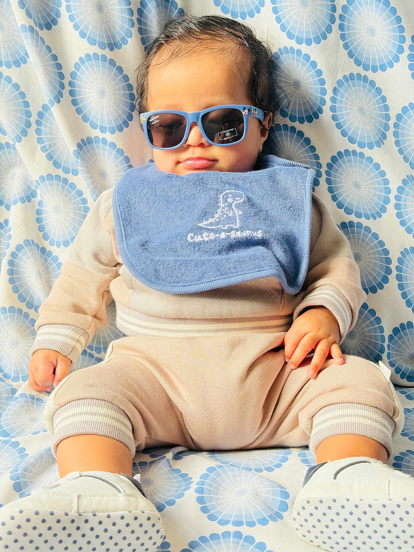 Censio joined the competition — help win amazing prizes! baby, child, sunglasses, bib, cute, sitting, clothing, footwear, patterned_background, blue, beige, portrait, indoor, infant, hand, face, head, smile, fashion, casual