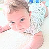 baby, infant, tummy_time, onesie, milk_carton_pattern, blanket, soft_texture, curious_expression, indoor, bottle, furniture, child, cute, person, skin, head, arm, hand, foot, home