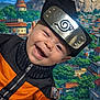 Rory is registered to the contest to win money with this photo: child, baby, infant, smile, cosplay, headband, metal_plate, costume, orange_jumpsuit, anime_background, village, mountains, buildings, trees, happy, portrait, close_up, person, cheeks, teeth