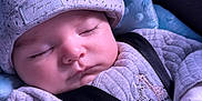 Salim is registered to the contest to win money with this photo: baby, blanket, blue, child, closeup, clothing, comfort, cozy, cushion, cute, face, hat, indoors, infant, peaceful, portrait, rest, sleeping, soft, strap