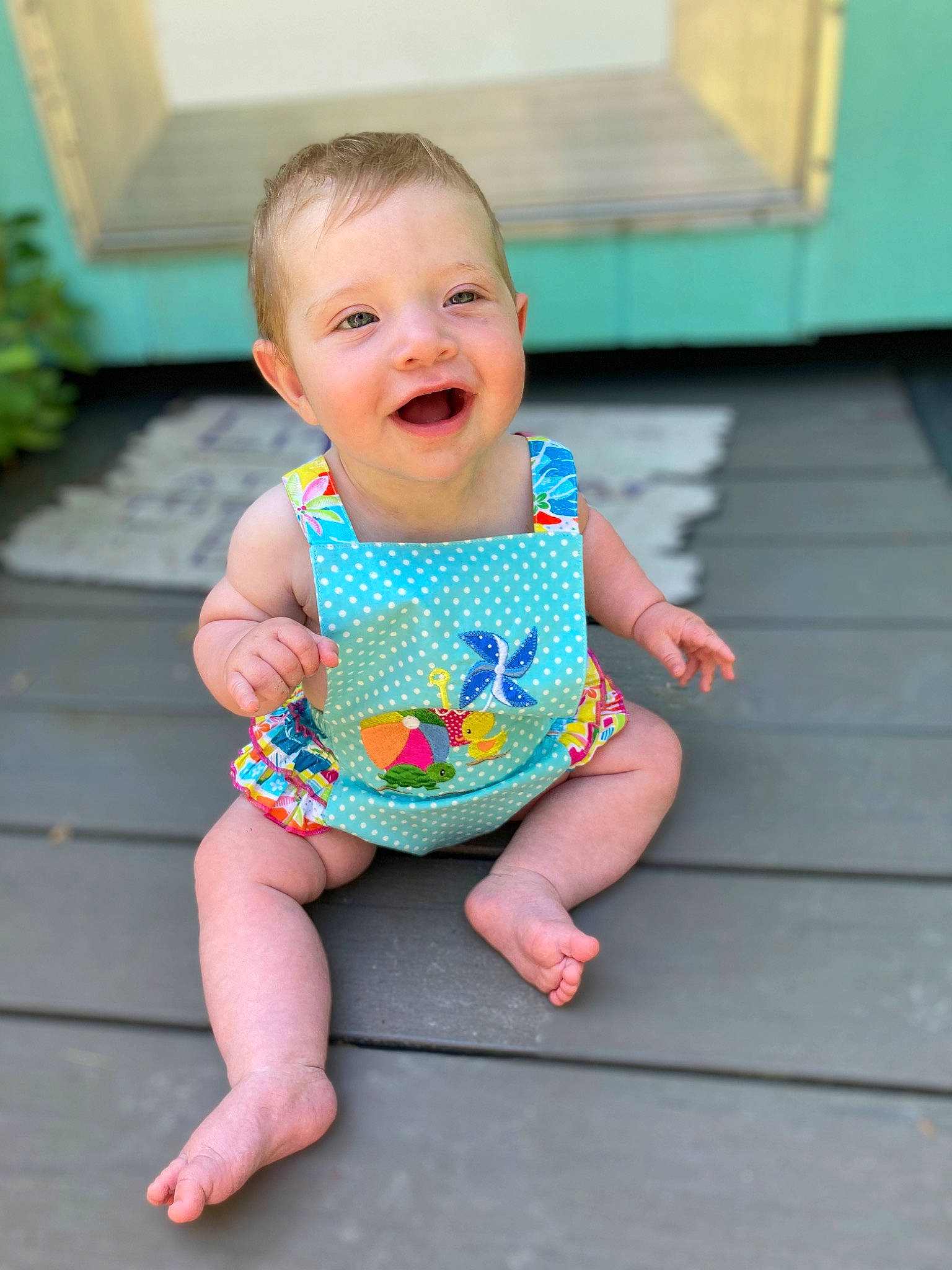 Daphne is registered to the contest to win money with this photo: aqua, baby, baby_toddler_clothing, barefoot, clothing, finger, foot, fun, grass, happy, head, joy, leisure, pattern, person, pink, skin, sleeve, smile, standing