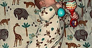 Waylon joined the competition — help win amazing prizes! baby, infant, rattle, blanket, animal_print, elephant, giraffe, leopard, onesie, footed_pajamas, toy, pattern, lying_down, cute, child, indoor, soft_texture, sleepwear, colorful, playful
