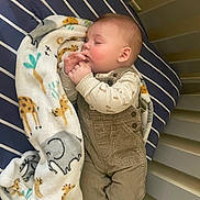Waylon joined the competition — help win amazing prizes! baby, sleeping, crib, blanket, animal_print, giraffe, elephant, overalls, clothing, infant, hands, face, peaceful, cute, bed, socks, child, indoors, resting, toddler