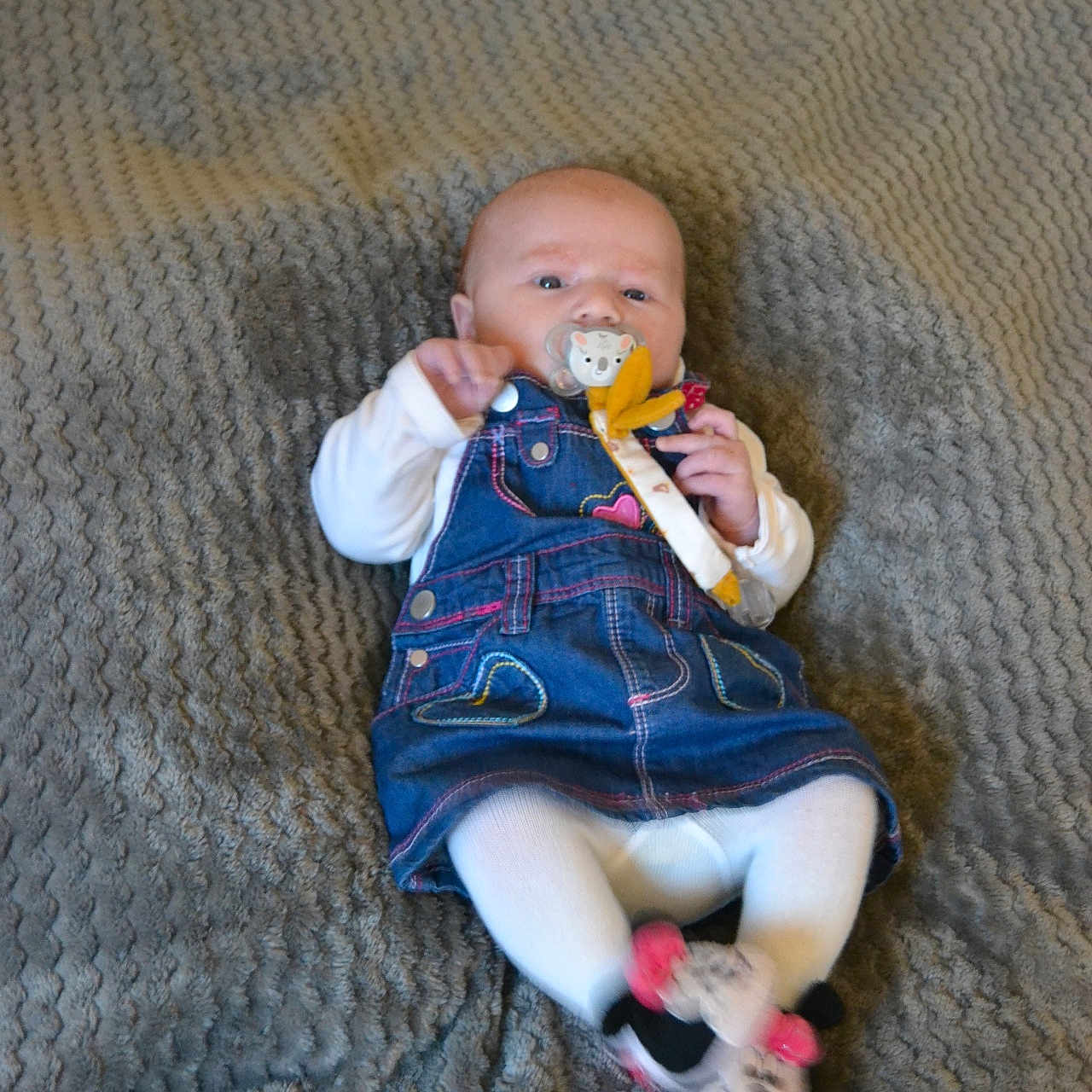 Iris participe au concours pour gagner de l'argent avec cette photo : baby, blanket, child, clothing, cute, denim_dress, face, feet, hands, head, indoors, infant, lying_down, minnie_mouse, pacifier, person, slippers, small, textured, white_tights