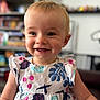 Lucy a rejoint le concours — aidez-le/la à gagner de superbes lots ! toddler, child, smile, happy, dress, patterned_clothing, indoor, portrait, face, baby, blond_hair, cute, person, young_child, sitting, closeup, cheerful, background_blur, room, infant