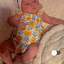 baby, infant, blanket, headband, flower_pattern, clothing, blue_eyes, skin, cute, newborn, lying_down, soft_texture, hand, foot, yellow, white, portrait, child, sleepwear, fabric