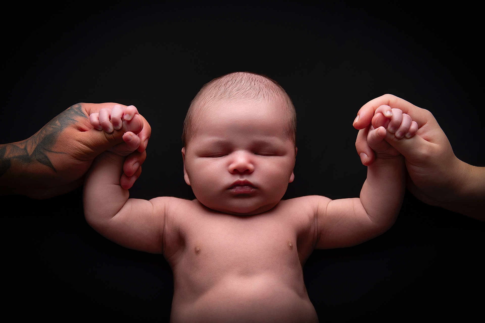 Elijah is registered to the contest to win money with this photo: baby, infant, hands, holding, tattoo, peaceful, sleeping, skin, closeup, portrait, newborn, human, parental, connection, black_background, soft_light, cute, child, love, tenderness