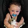 Alessio a rejoint le concours — aidez-le/la à gagner de superbes lots ! baby, child, pacifier, car_seat, curly_hair, blue_eyes, holding, spray_canister, black, straps, cute, skin, cheeks, seatbelt, infant, hands, portrait, indoor, expression, sitting