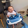 baby, walker, blue, white, toy, steering_wheel, smiling, happy, indoor, floor, tile, chair, pet_bed, foot, person, child, cute, hair, clothing, home