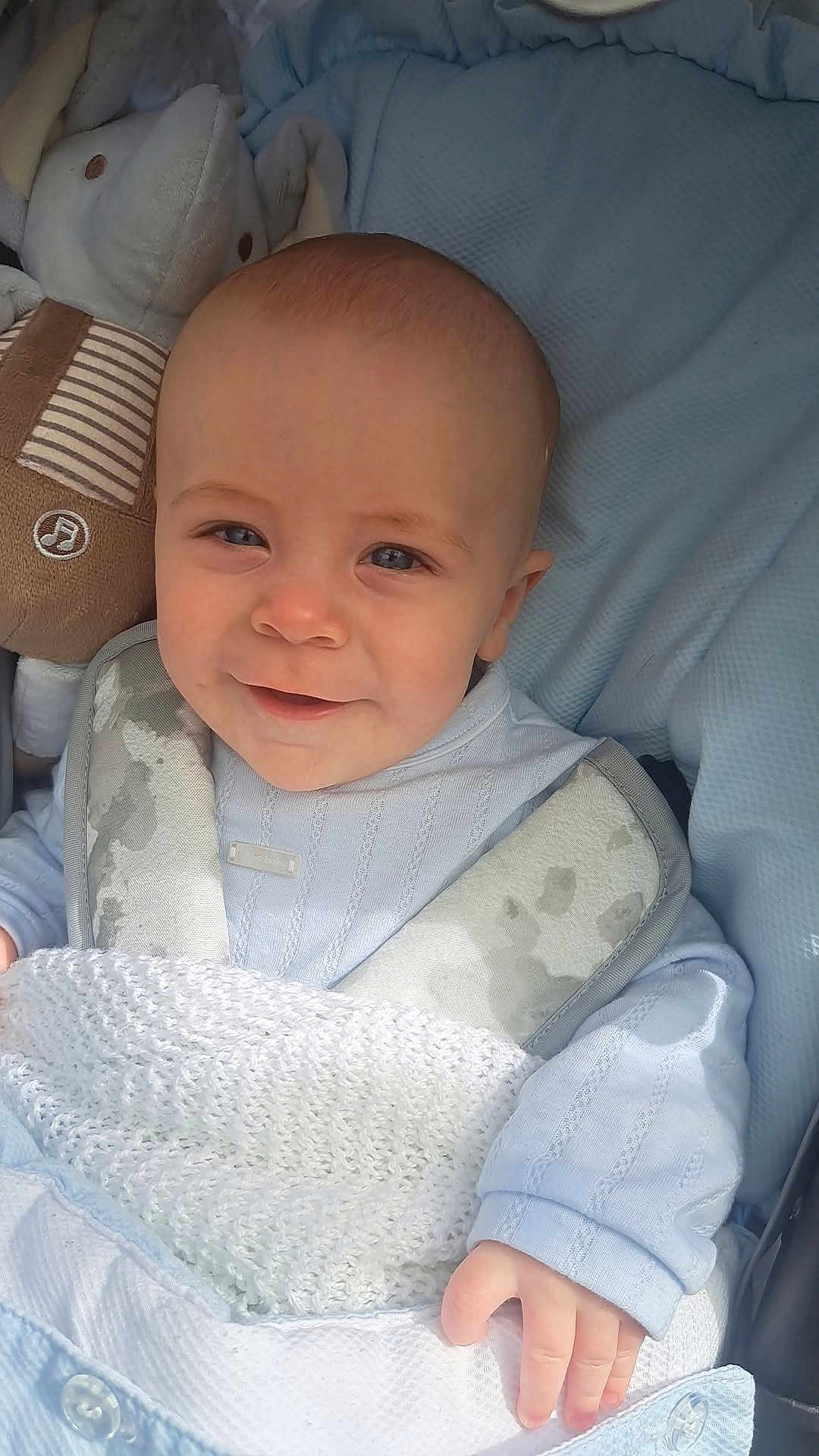 Arran is registered to the contest to win money with this photo: baby, baby_carrier, blanket, blue, bunny, child, clothing, cozy, cute, face, hand, indoors, infant, lying_down, plush_toy, portrait, smile, soft_toys, warm, white