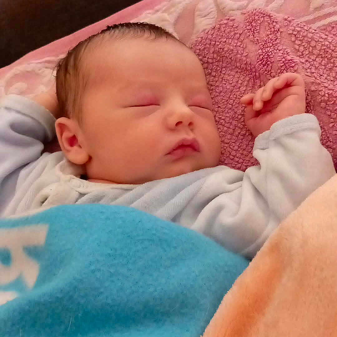 Mylan participe au concours pour gagner de l'argent avec cette photo : baby, sleeping, blanket, newborn, infant, cozy, soft, pink, blue, hand, face, head, clothing, indoor, couch, comfort, peaceful, rest, portrait, child