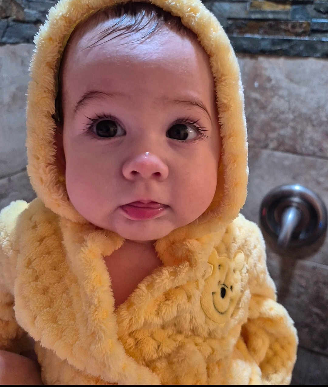 Zulema joined the competition — help win amazing prizes! baby, child, face, hood, yellow, fluffy, cute, portrait, infant, clothing, smile, eyes, indoors, warm, soft, expression, tiled_wall, closeup, adorable, person