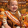 baby, crown, trophy, thanksgiving, pumpkin, autumn, sash, smile, child, holiday, celebration, cute, orange, gold, festive, leaves, costume, portrait, happy, seasonal