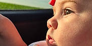 Zulema joined the competition — help win amazing prizes! baby, child, profile, face, headband, pink, bow, bib, car, window, sky, clouds, sunlight, closeup, cute, infant, soft_light, portrait, expression, thoughtful