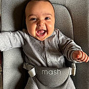 Rafael is registered to the contest to win money with this photo: baby, infant, smile, happy, grey_clothing, baby_seat, straps, face, mouth_open, arms_outstretched, indoor, child, cute, joyful, person, one_person, young_child, seat, fabric, closeup