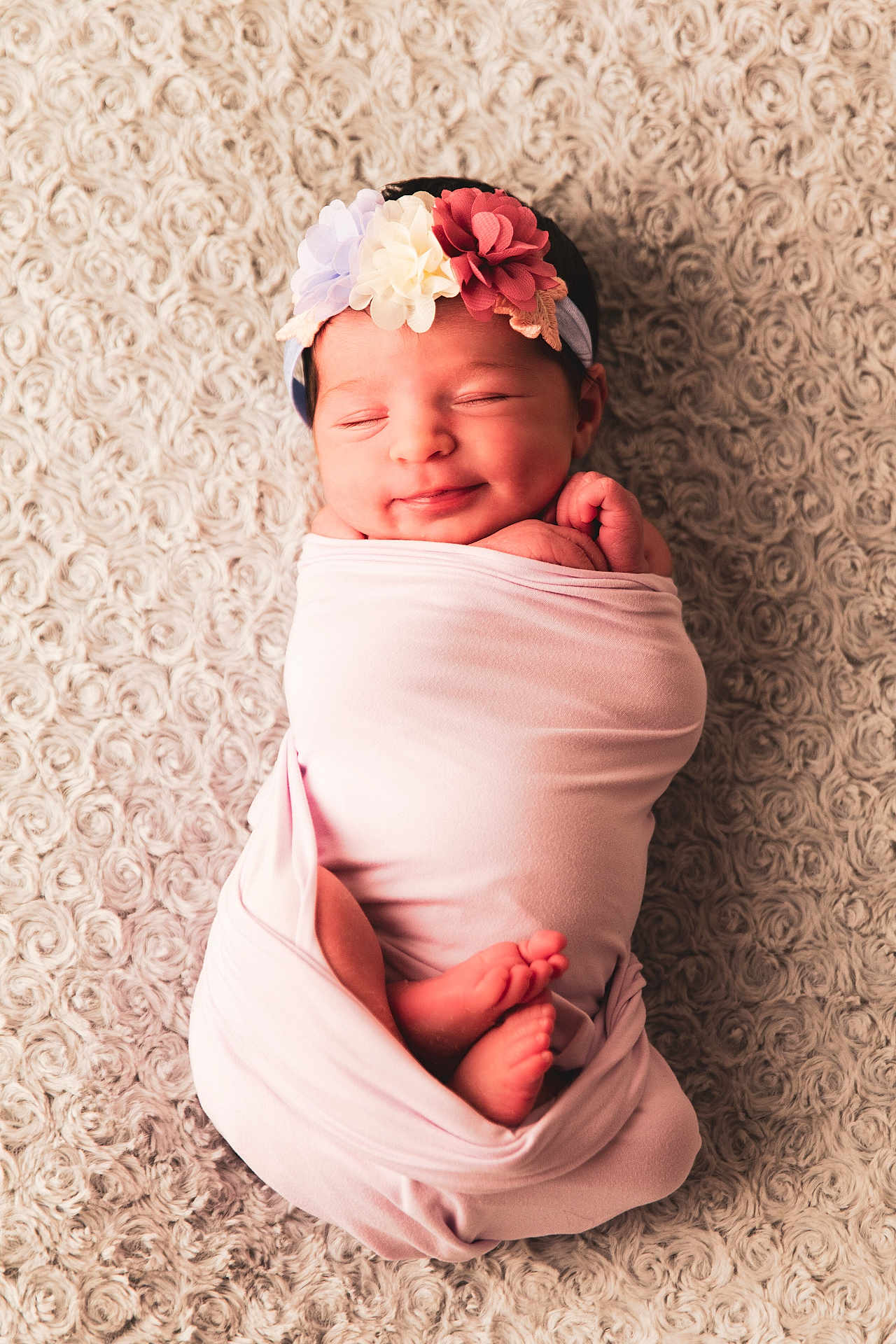 Emma participe au concours pour gagner de l'argent avec cette photo : newborn, baby, swaddled, pink_blanket, flower_headband, sleeping, smiling, infant, cozy, soft_texture, cute, resting, peaceful, portrait, child, wrapped, small_feet, headwear, indoor, closeup