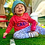 toddler, child, smiling, hat, bucket_hat, sweatshirt, pink, toy, grass, outdoor, daylight, happy, playing, sitting, footwear, white_shoes, casual_clothing, blurred_background, portrait, closeup