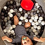baby, child, pacifier, ball_pit, balls, toy_ball, striped_clothing, arms_outstretched, indoor, flooring, grey_ball_pit, white_balls, black_balls, translucent_balls, red_ball, purple_ball, cute, lying_down, infant, playtime
