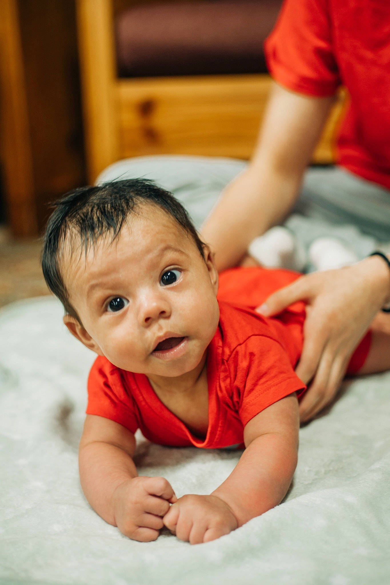 Joel is registered to the contest to win money with this photo: baby, baby_toddler_clothing, black_hair, cheek, child, comfort, elbow, finger, flash_photography, flooring, fun, gesture, hand, happy, leisure, nose, person, skin, surprise, t_shirt