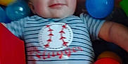 Remington joined the competition — help win amazing prizes! baby, child, smiling, striped_onesie, baseball_design, ball_pit, red_ball, yellow_ball, blue_ball, translucent_ball, playful, happy, infant, cute, indoor, colorful, person, face, young_child, toy