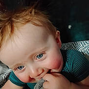 Remington is registered to the contest to win money with this photo: baby, child, blue_eyes, blond_hair, blanket, cheeks, close_up, cute, face, hand, indoor, infant, looking_at_camera, nibble, playful, portrait, soft_texture, smiling, toddler, young_child