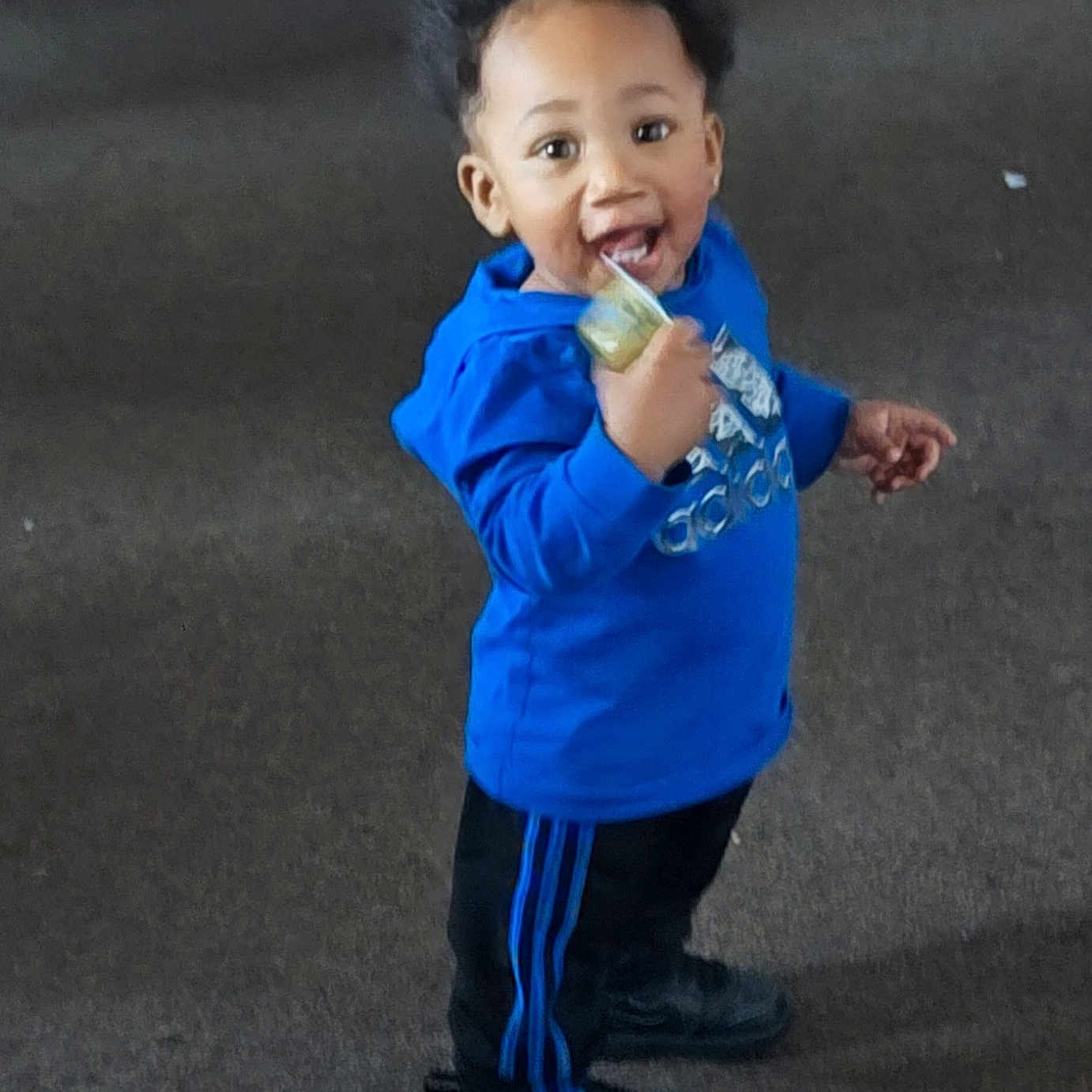 Panthir joined the competition — help win amazing prizes! toddler, child, blue_hoodie, black_pants, standing, smiling, snack_pouch, indoor, carpet, happy, person, young_child, casual_clothing, footwear, curly_hair, cute, playful, bright_clothing, full_body, portrait