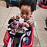 Panthir joined the competition — help win amazing prizes! toddler, child, plush_toy, walker, toy, indoor, floor, tile_floor, person, baby, hands, curly_hair, clothing, red_walker, black_handle, purple_strap, facial_expression, baby_toy, concentration, home