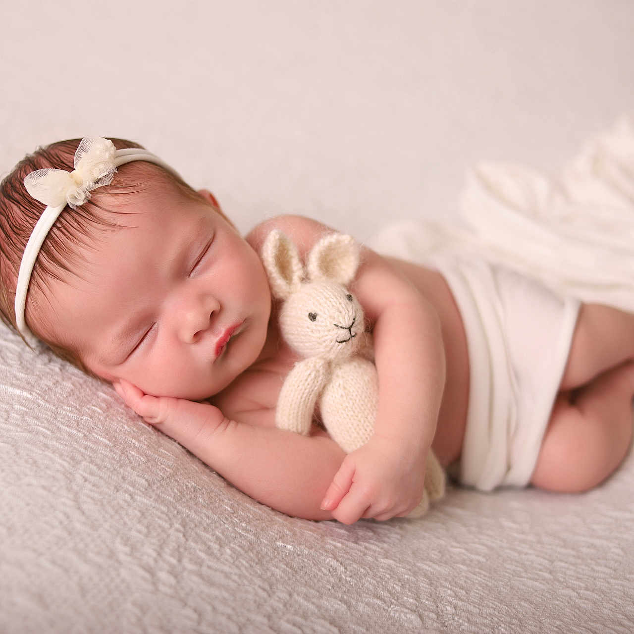 Harriet is registered to the contest to win money with this photo: adorable, baby, child, cuddling, cute, feet, hand, headband, infant, knitted_bunny, laying_down, newborn, peaceful, portrait, resting, sleeping, soft_texture, tender, white_blanket, wrapped