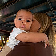 Harrison is registered to the contest to win money with this photo: baby, child, person, indoor, holding, adult, face, curious, closeup, portrait, warm_lighting, wooden_beams, clothing, expression, candid, family, love, toddler, skin, arm
